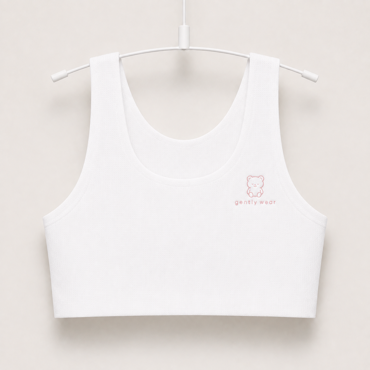 Gently first bra in white with embroidered bear logo, seamless wire-free longline crop on a hanger