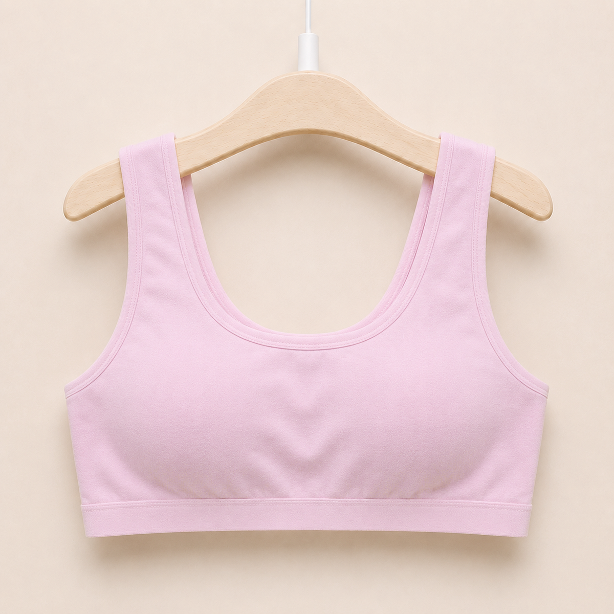 The Cotton One in soft pink on a hanger - wire-free cotton training bra for girls